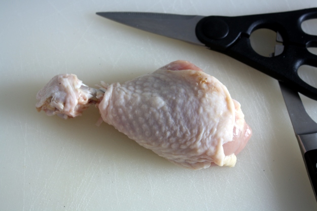 2: With sharp kitchen shears, cut the skin and membrane at the bottom of the drumstick.